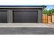 Modern two car garage with a dark gray door and a concrete driveway at 2450 S Cherokee St, Denver, CO 80223