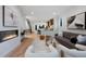 Bright, open-concept living room with a fireplace and hardwood floors at 2450 S Cherokee St, Denver, CO 80223