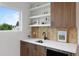 Stylish wet bar with a beverage cooler, modern fixtures and decorative floating shelves at 2450 S Cherokee St, Denver, CO 80223