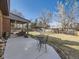 A spacious backyard with a concrete patio, seating, mature trees, and a wood fence at 3361 W Saratoga Ave, Englewood, CO 80110