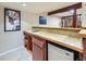 Finished basement bar with a mini fridge, sink, and decorative tile backsplash at 3361 W Saratoga Ave, Englewood, CO 80110
