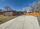 An exterior shot of a well-maintained brick home with a neatly paved driveway leading to the garage at 3361 W Saratoga Ave, Englewood, CO 80110