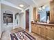Hallway with a patterned rug leading to a bathroom sink and vanity with wooden cabinetry at 3361 W Saratoga Ave, Englewood, CO 80110