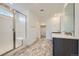 Modern bathroom with tiled floors, glass-enclosed shower, and dual vanities with modern fixtures at 4619 Windmill Dr, Brighton, CO 80601