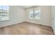 Bright bedroom features wood flooring and views of neighboring homes from the large double windows at 4619 Windmill Dr, Brighton, CO 80601