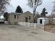 Backyard with an external shed and a concrete driveway bordered by a white picket fence at 1120 Dayton St, Aurora, CO 80010