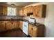 Lovely kitchen featuring tile backsplash, wooden cabinets, black countertops, and hardwood floors at 1120 Dayton St, Aurora, CO 80010