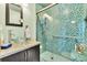 Modern bathroom with glass vessel sink, stylish vanity, and shower featuring blue mosaic tiles at 377 S Grant St, Denver, CO 80209