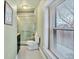 Well-lit bathroom featuring a shower with green tile and a large window providing natural light at 377 S Grant St, Denver, CO 80209