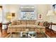 Bright living room with a floral sofa, glass coffee table, hardwood floors, and a large window at 377 S Grant St, Denver, CO 80209