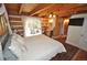 Comfortable bedroom with wood beam ceiling, wood floors, a queen-size bed, and access to an outdoor patio at 9716 Canon Dr, Sedalia, CO 80135