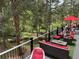 Relaxing outdoor deck with comfortable seating, a red umbrella, and views of the lush surrounding forest at 9716 Canon Dr, Sedalia, CO 80135