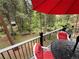 Inviting deck space with a red umbrella, outdoor seating, and scenic views of the wooded landscape at 9716 Canon Dr, Sedalia, CO 80135
