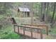 Quaint building with a stone exterior, accessed by a wooden bridge and staircase, nestled in a wooded area at 9716 Canon Dr, Sedalia, CO 80135