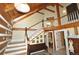 Grand foyer with wood staircase, vaulted ceilings with wood beams, and views to the upper level at 9716 Canon Dr, Sedalia, CO 80135