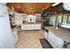 Spacious kitchen featuring white cabinetry, tile floors, granite countertops and a wood beam ceiling at 9716 Canon Dr, Sedalia, CO 80135