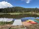 Lakeside scene featuring a tranquil lake with a dock, surrounded by canoes, and lush greenery at 9716 Canon Dr, Sedalia, CO 80135