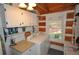 Cozy laundry room featuring wood paneled walls, ample storage, and a bright window at 9716 Canon Dr, Sedalia, CO 80135
