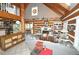 Inviting living room with high vaulted ceilings, wood beams, fireplace, and open layout to the kitchen and dining area at 9716 Canon Dr, Sedalia, CO 80135