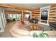 Bright living room with wood-paneled walls, tile flooring, and open layout with views to the outside at 9716 Canon Dr, Sedalia, CO 80135