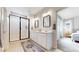 Modern bathroom with a double vanity, white cabinets, walk-in shower, and neutral color palette at 3625 Silver Rock Cir, Castle Rock, CO 80104