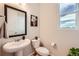Cozy bathroom with modern sink and fixtures, decorative mirror, and window to let in natural light at 3625 Silver Rock Cir, Castle Rock, CO 80104
