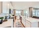 Bright kitchen with white cabinetry, stainless appliances, a large island, and an adjacent dining area at 3625 Silver Rock Cir, Castle Rock, CO 80104