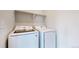 Bright laundry room features a modern, front-loading Samsung washer and dryer and shelf storage at 3625 Silver Rock Cir, Castle Rock, CO 80104