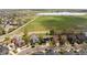 An aerial view shows homes in a neighborhood, including backyards, fences, and a lake at 5249 Mt Arapaho Cir, Frederick, CO 80504