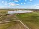 A calm lake is next to a residential neighborhood from an aerial view, with trails and lush fields at 5249 Mt Arapaho Cir, Frederick, CO 80504