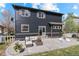 A cozy outdoor seating area is adjacent to the home featuring dark siding and a concrete patio at 5249 Mt Arapaho Cir, Frederick, CO 80504