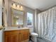 Bright bathroom with a wood vanity, a large framed mirror, and a shower with a decorative cat shower curtain at 5249 Mt Arapaho Cir, Frederick, CO 80504