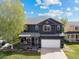 Charming two-story home with covered front porch, hanging flower baskets, and well-manicured landscaping at 5249 Mt Arapaho Cir, Frederick, CO 80504