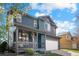 Charming two-story home with covered front porch, hanging flower baskets, and a lush front yard at 5249 Mt Arapaho Cir, Frederick, CO 80504