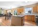 Open kitchen featuring stainless appliances, an island, and views into the dining area and living room at 5249 Mt Arapaho Cir, Frederick, CO 80504