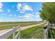 A peaceful, grassy field extends beyond a charming white picket fence, creating a tranquil setting at 5249 Mt Arapaho Cir, Frederick, CO 80504