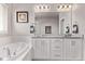 Bright bathroom featuring double vanity with granite countertop, soaking tub, and modern fixtures at 6990 E 132Nd Pl, Thornton, CO 80602