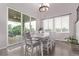Bright dining room with modern chandelier, large windows, and sliding glass door to patio at 6990 E 132Nd Pl, Thornton, CO 80602