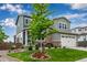 Beautifully landscaped front yard with a mature tree and colorful flower beds enhancing curb appeal at 6990 E 132Nd Pl, Thornton, CO 80602