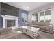 Cozy living room with a fireplace, large TV, and comfortable seating area with natural light at 6990 E 132Nd Pl, Thornton, CO 80602