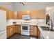 Well-lit kitchen boasts natural wood cabinets, white appliances, and ample counter space at 2800 W Centennial Dr # I, Littleton, CO 80123