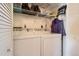 Functional laundry room with full-size washer and dryer, shelving, and built in storage at 2800 W Centennial Dr # I, Littleton, CO 80123
