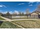 Community pool surrounded by a black metal fence and landscaped green space under a partly cloudy sky at 2800 W Centennial Dr # I, Littleton, CO 80123