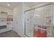 Clean, well-lit bathroom features glass door shower, tiled flooring and convenient shelving at 6513 14Th St, Frederick, CO 80530