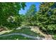 An elevated view of the backyard features a stone garden, lush lawn, mature trees, and a wood fence at 7773 Gunsight Pass, Littleton, CO 80127