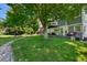 Lush backyard with manicured lawn, a large shade tree, stone-lined walking path at 7773 Gunsight Pass, Littleton, CO 80127