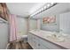 The bright bathroom boasts a double vanity, large mirror, pink accents, and a shower-tub combination at 7773 Gunsight Pass, Littleton, CO 80127