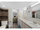 Well-lit bathroom with a double sink vanity, updated fixtures, and attached bedroom at 7773 Gunsight Pass, Littleton, CO 80127