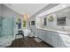 A luxurious bathroom features a glass-enclosed shower, soaking tub, double vanity, and wood-look flooring at 7773 Gunsight Pass, Littleton, CO 80127