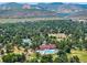 Overhead view of tennis courts, clubhouse, and pool in lush green surroundings at 7773 Gunsight Pass, Littleton, CO 80127